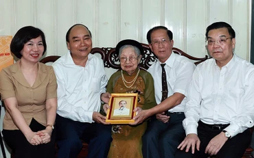 Chủ tịch nước Nguyễn Xuân Phúc thăm và tặng quà bà Nguyễn Thị Tú, mẹ liệt sĩ Nguyễn Thái Lai. (Ảnh: Thống Nhất/TTXVN)