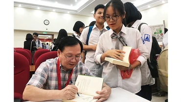 “Hiệp sĩ Dế Mèn Nguyễn Nhật Ánh” tặng chữ ký cho độc giả sau khi nhận giải.