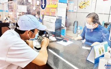 Hành khách đến ga Sài Gòn lấy số thứ tự rồi mua vé Tết ngay, không cần lên mạng đặt chỗ, "săn" vé tàu Tết như mọi năm.
