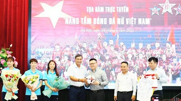 Huấn luyện viên Mai Đức Chung và các tuyển thủ nữ tặng Báo Nhân Dân bóng và áo thi đấu có chữ ký. Ảnh: THÀNH ĐẠT