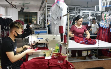 Công nhân Công ty cổ phần Nam Tiệp (Cụm công nghiệp An Xá, TP Nam Ðịnh, tỉnh Nam Ðịnh) may quần áo hàng xuất khẩu sang thị trường Nga, châu Âu, Mỹ. Ảnh: NAM ANH 