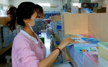 Nhân viên soạn sách giáo khoa theo đơn đặt hàng của khách. (Ảnh: Thu Hiền/TTXVN)
