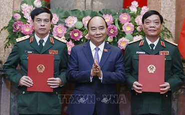 Chủ tịch nước Nguyễn Xuân Phúc, Thống lĩnh các lực lượng vũ trang nhân dân, Chủ tịch Hội đồng Quốc phòng và An ninh trao Quyết định thăng quân hàm từ Trung tướng lên Thượng tướng đối với đồng chí Ngô Minh Tiến và Lương Đình Hồng. (Ảnh: TTXVN)