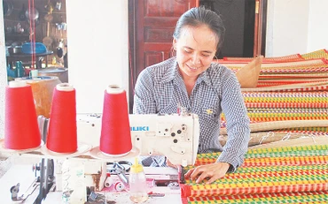 Nghề gia công chiếu thảm giúp người dân xã Ðức Mỹ, huyện Càng Long (Trà Vinh) nâng cao thu nhập. 