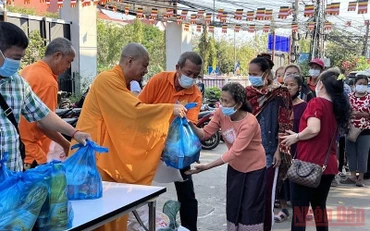 Thượng tọa Thích Minh Quang (thứ 3 từ trái qua) trao hỗ trợ kiều bào nghèo ở Thủ đô Vientiane trong lễ Thượng nguyên 2022. (ẢNH: XUÂN SƠN)
