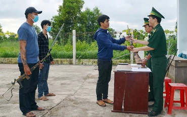 Người dân địa phương tự giác giao nộp vũ khí cho cán bộ, chiến sĩ Ðồn Biên phòng Ia R’vê (Ðắk Lắk). Ảnh: NGỌC LÂN