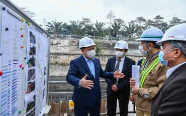 Đồng chí Vương Đình Huệ cùng các đồng chí lãnh đạo thành phố kiểm tra tại công trường xây dựng hệ thống cống bao cho sông Tô Lịch. (Ảnh: Duy Linh)