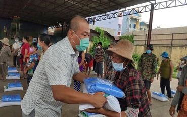 Cán bộ Đại sứ quán nước ta trao quà cứu trợ cho bà con.