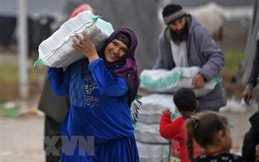 Người tị nạn Syria nhận hàng viện trợ. (Ảnh: AFP/TTXVN)