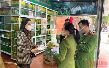 Cán bộ Đội cảnh sát phòng cháy, chữa cháy và cứu nạn cứu hộ (Công an quận Thanh Xuân, Thành phố Hà Nội) phát tờ rơi, tuyên truyền phòng chống cháy nổ tại một cửa hàng kinh doanh trà tại phường Thanh Xuân Bắc.