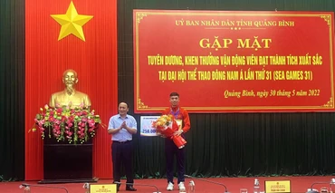 Phó Bí thư Thường trực Tỉnh ủy Quảng Bình Trần Hải Châu trao thường và tặng hoa cho Nguyễn Huy Hoàng.