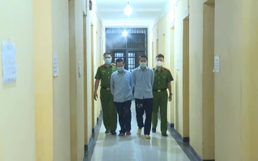 Lực lượng Công an dẫn giải hai đối tượng cầm đầu sàn tiền ảo.