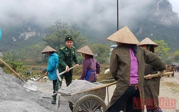 Thượng tá Mê Văn Đạt, Bí thư Đảng ủy xã Đàm Thủy cùng làm đường với dân. Ảnh: NGUYÊN PHONG