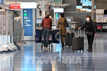 Hành khách tại sân bay Haneda ở thủ đô Tokyo, Nhật Bản, ngày 1/12/2021. (Ảnh: AFP/TTXVN)