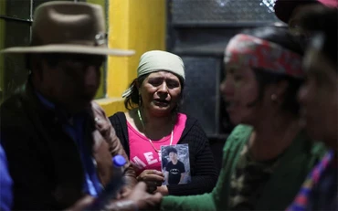 Mẹ của nạn nhân 13 tuổi trong vụ việc này cầm di ảnh của con trai. (Ảnh: Reuters)