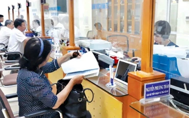 Cán bộ UBND quận Hoàn Kiếm tiếp nhận, hướng dẫn người dân làm thủ tục hành chính tại bộ phận “Một cửa”.