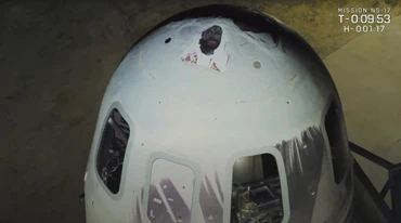 Tổ hợp tên lửa - tàu vũ trụ New Shepard của Blue Origin trước khi được phóng lên vũ trụ. Các bức chân dung được dán lên mũi tàu. (Ảnh: cắt từ video clip của Blue Origin)