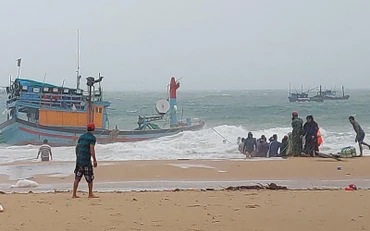 Người dân cùng lực lượng cứu hộ nỗ lực cứu hộ tàu thuyền bị sóng lớn đánh chìm tại bãi biển Long Thuỷ, An Phú, thành phố Tuy Hòa.