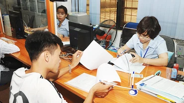 Người lao động làm thủ tục về bảo hiểm xã hội tại Trung tâm giới thiệu việc làm Hà Nội. Ảnh: HẢI NAM