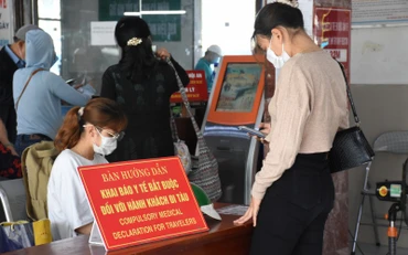 Nhân viên Ga Đà Nẵng hướng dẫn người dân khai báo y tế trước khi lên tàu.