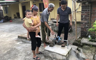 Tổ vận hành công trình nước sinh hoạt xã Hoàng Tung, huyện Hòa An (Cao Bằng) đi chốt số nước tại nhà dân.