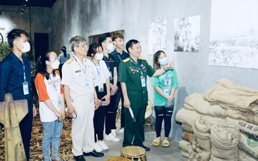 Các cựu chiến binh, các em học sinh tham quan triển lãm.