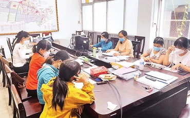 Nhân viên tư vấn, hỗ trợ F0 gọi điện thăm hỏi người bệnh từ Trung tâm Chỉ huy phòng, chống dịch Covid-19 xã Xuân Thới Thượng, huyện Hóc Môn. 