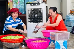 Bà Lý (bìa trái) tham gia chia khẩu phần thức ăn phục vụ bữa trưa 18/9. (Ảnh: THANH SƠN)