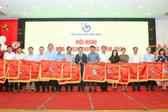 Chủ tịch Hội Nhà báo Việt Nam Lê Quốc Minh trao Cờ thi đua tặng tập thể có thành tích xuất sắc.