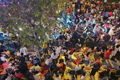 Các vỉa hè ở các trục đường các khối diễu binh đi qua đều kín người ngồi. (Ảnh: HẢI AN)