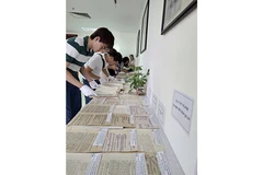 Người xem tìm hiểu nội dung các tài liệu trưng bày.