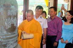 Thượng tọa Thích Giác Nghĩa cùng lãnh đạo Quân chủng Hải quân thỉnh chuông cầu nguyện cho các Anh hùng liệt sĩ tại đảo Sinh Tồn. Ảnh: Minh Tư