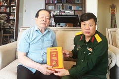 Nhà văn Phùng Văn Khai (phải) tặng nhà thơ Hữu Thỉnh cuốn tiểu thuyết mới “Trưng nữ vương”.