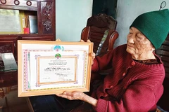 Bà Liên nâng niu tấm bằng công nhận thành tích người cao tuổi mẫu mực, nêu gương sáng vì sự nghiệp xây dựng và bảo vệ Tổ quốc.