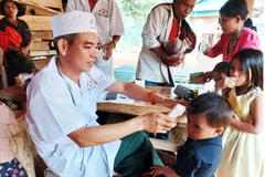 Thiếu tá quân nhân chuyên nghiệp Trần Minh Vũ, y sĩ quân y Đồn Biên phòng A Vao) khám, chữa bệnh cho bà con Pa Ling.