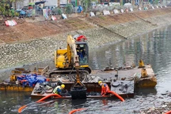 Công nhân Công ty Thoát nước Hà Nội tiến hành nạo vét bùn trên sông Tô Lịch. (Ảnh: Phong Anh)