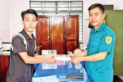Em Mã Thành Long (trái) nộp đơn tình nguyện nhập ngũ. 