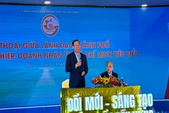 Chủ tịch Ủy ban nhân dân Thành phố Hồ Chí Minh Phan Văn Mãi (người đứng) và Chủ tịch HUBA Nguyễn Ngọc Hòa đối thoại với doanh nghiệp, doanh nhân tại buổi lễ.