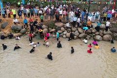 Từ bao đời nay, cuộc sống của người Thái luôn gắn liền với những con sông, con suối. (Trong ảnh: Bà con thi bắt cá suối.)