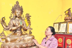 Nghệ nhân Bùi Thị Minh bên tác phẩm của gia đình.