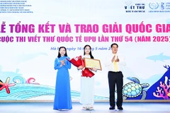 Minh Khuê (đứng giữa) nhận bằng khen và hoa trong lễ tổng kết và trao giải.