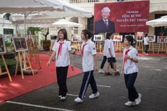 Giáo viên và học sinh trường THCS Hoàn Kiếm tham quan triển lãm ảnh.