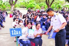 Báo cáo viên tuyên truyền, phát tờ rơi về thu hút nguồn nhân lực tại Trường THPT Hùng Vương, thành phố Quy Nhơn. (Ảnh THANH SANG)