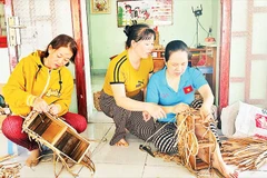 Chị em phụ nữ Tổ hợp tác đan lục bình Hồng Lan-Long Sơn hướng dẫn nhau đan các sản phẩm từ lục bình.