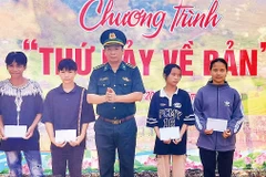 Ðại diện Ban Chỉ huy Ðồn Biên phòng Cà Xèng trao quà tặng học sinh người Rục ở xã Thượng Hóa, huyện Minh Hóa, tỉnh Quảng Bình.