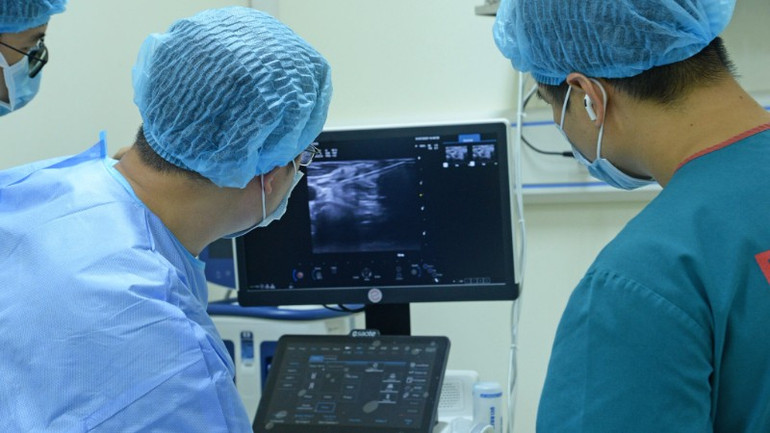Dưới hướng dẫn siêu âm, ê-kíp bác sĩ Bệnh viện Nội tiết Trung ương đã sử dụng đầu kim đốt chuyên dụng tiếp cận chính xác khối hạch, áp dụng kỹ thuật moving-shot và bơm dịch ngăn cách nhằm bảo vệ các mạch máu lớn xung quanh. noi-tiet-1-2477.jpg