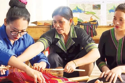 Nghệ nhân H'Yon (giữa) tỉ mỉ truyền dạy cho các học viên về cách tạo hoa văn trên nền thổ cẩm truyền thống của người M'nông bản địa.