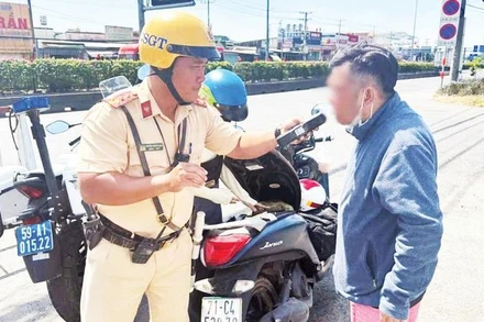 Cảnh sát giao thông kiểm tra nồng độ cồn của người điều khiển phương tiện tham gia giao thông.