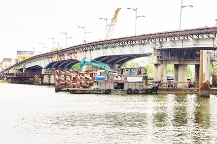 Nâng tĩnh không cầu Bình Triệu 1 nhằm bảo đảm tàu bè lưu thông, vận chuyển hàng hóa thuận tiện trên sông Sài Gòn. (Ảnh THẾ ANH)