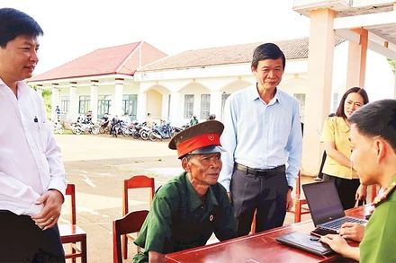 Lãnh đạo xã Bù Đăng hỗ trợ nhân dân giải quyết thủ tục hành chính.